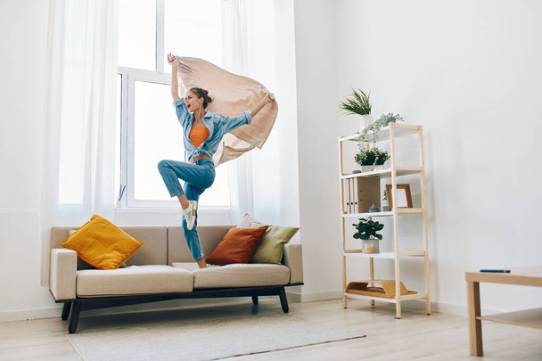 Radosny skok: Szczęśliwa kobieta tańczy i śpiewa w swoim domu zabawy - Zdjęcie, obraz