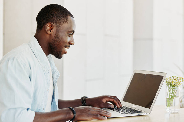 Tecnologia homem empresário estilo de vida cara adulto sorrindo digitando laptop usando computador masculino negócios on-line trabalhando preto jovem feliz internet moderno pessoa de escritório sentado - Foto, Imagem