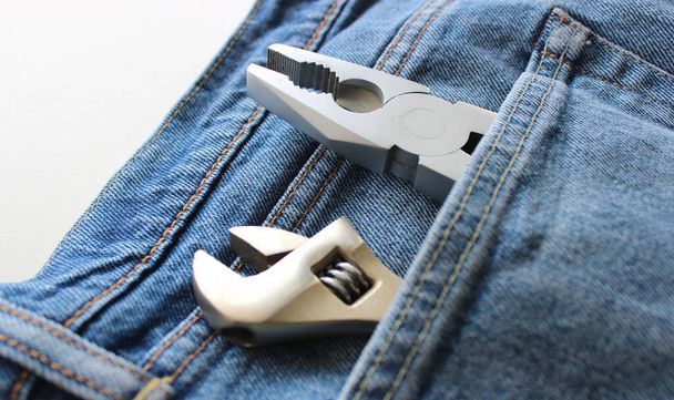 Vue d'angle rapprochée des têtes d'outils de fixation sortant d'une poche en tissu de jeans. Outils et équipements ménagers Photo de stock - Photo, image