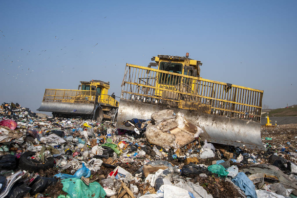 Residuos municipales. Trabajadores con camiones y excavadoras en el trabajo en vertederos de almacenamiento de residuos. - Foto, Imagen