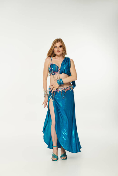 Jovem mulher de vestido azul graciosamente posando para uma performance de dança. - Foto, Imagem