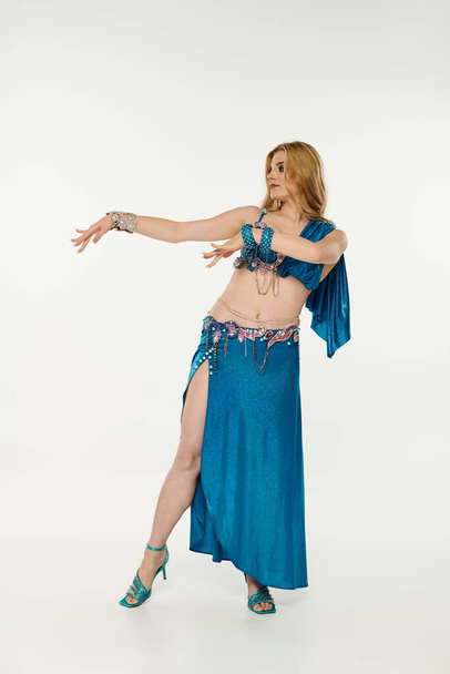 A captivating young woman in a vibrant blue belly dance outfit. - Fotoğraf, Görsel