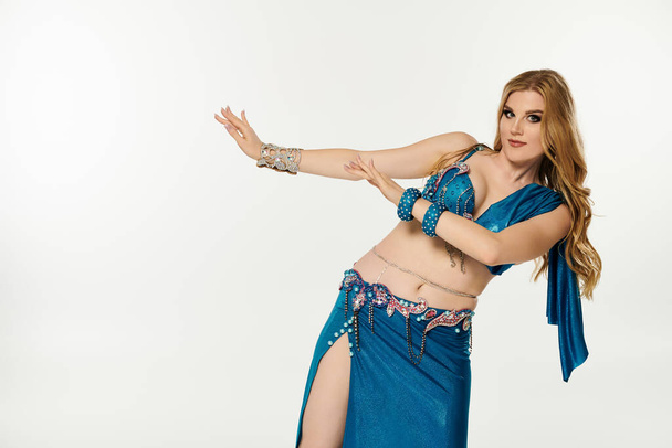 Graceful woman in blue belly dance attire sways elegantly. - Photo, Image