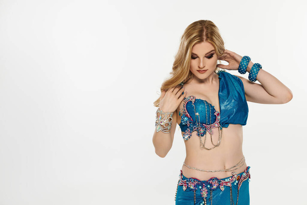 Woman in stunning blue belly dance attire showcasing graceful moves. - Photo, Image