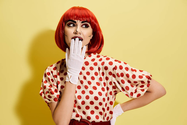 Een prachtige roodharige versierd met polka dot kleding en witte handschoenen tegen een levendige gele achtergrond geïnspireerd door stripfiguren. - Foto, afbeelding