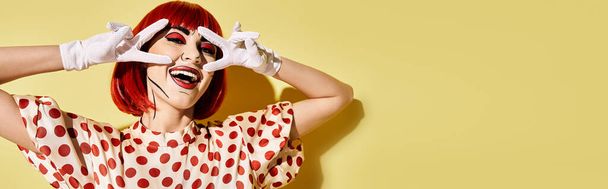 Uma mulher ruiva em luvas brancas cobre seus olhos, adicionando um ar de intriga e fascínio ao seu visual de personagem cômico pop art.. - Foto, Imagem