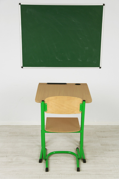 Чорна дошка і дерев'яний стіл зі стільцем в класі
 - Фото, зображення