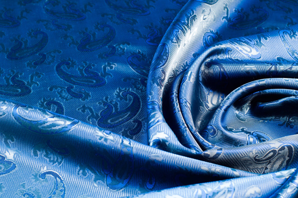 La textura de la tela de seda. Azul oscuro. Con una foto de pepinos. una fibra fina, fuerte, suave y brillante producida por gusanos de seda en la fabricación de capullos y recogida para hacer hilo y tela
 - Foto, imagen