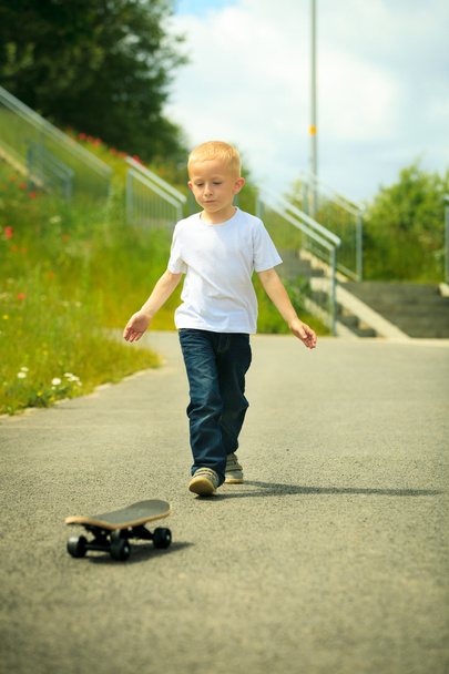 Skater boy child with his skateboard. Outdoor activity. - Фото, изображение