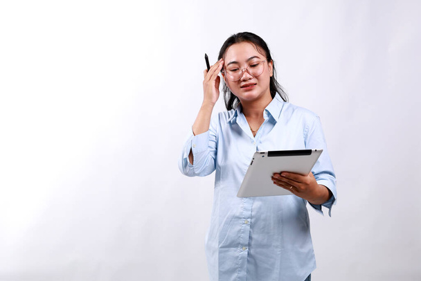 Portret kobiety biznesu azjatyckiego patrzącej na cyfrowy tablet ze zmartwioną, zestresowaną i zdenerwowaną twarzą. Odizolowane na biało - Zdjęcie, obraz