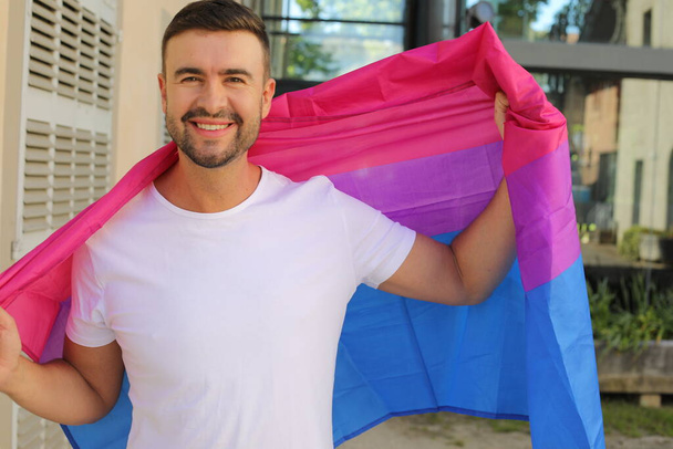 Trots man zwaaiend met de biseksuele vlag - Foto, afbeelding