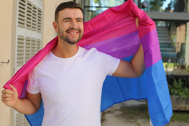 Homem orgulhoso agitando a bandeira bissexual - Foto, Imagem