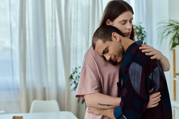 Um casal gay em roupas casuais compartilhando um abraço sincero em casa. - Foto, Imagem