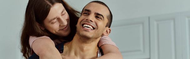 Muž něžně drží partnera v náručí, sdílí okamžik intimity a spojení mezi milujícím párem. - Fotografie, Obrázek