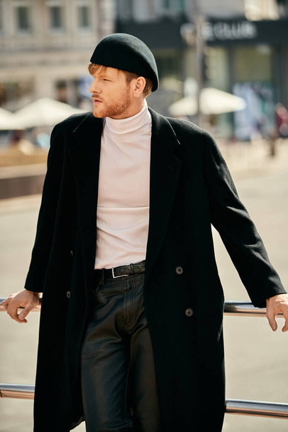 Joven hombre pelirrojo con abrigo negro y camisa blanca caminando con confianza en la ciudad. - Foto, imagen