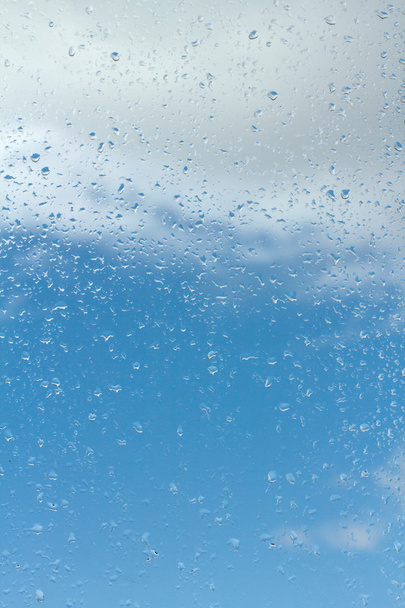 Gotas de agua sobre vidrio contra el cielo azul
 - Foto, imagen