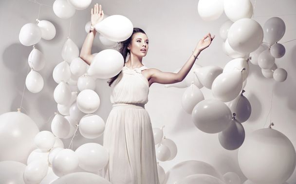 Adorable young woman holding many balloons - Foto, immagini
