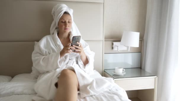 Kylpytakissa oleva nainen rentoutuu hotellin kylpylän jälkeen. - Materiaali, video