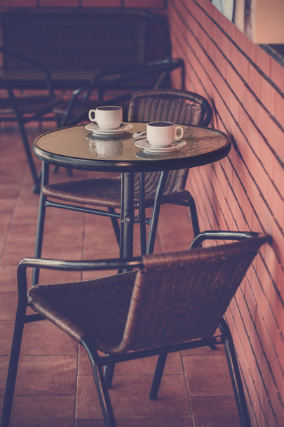 Типичная кофейная терраса со столом и стульями
 - Фото, изображение