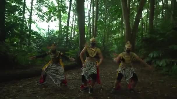 Geleneksel Balili dansçılar süslü kostümler ve maskeler içinde gür bir orman ortamında gösteri yapıyorlar, kültürel mirası ve sanatsal ifadeyi sergiliyorlar.. - Video, Çekim