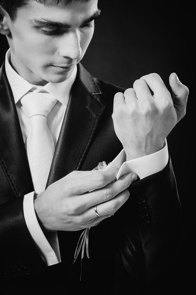 Les mains du marié se préparent en costume. fond studio noir
 - Photo, image