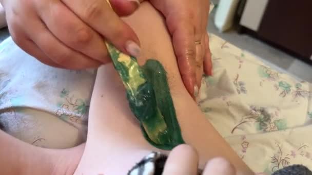 Depilation using hot wax under the armpits, green wax is applied to a young teenage girl hair. pulled off with a sharp movement. Melted wax depilation - Footage, Video
