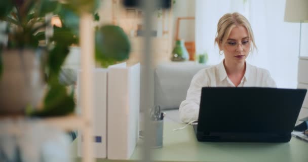 Çok çalışan iş kadını bilgisayarını kapatıyor ve yorucu bir iş gününden sonra gözlüklerini çıkarıyor. - Video, Çekim