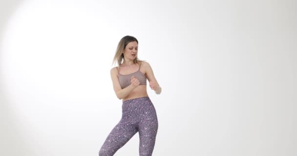 Mladá žena tančí na bílém pozadí 4k film zpomalení. Bezstarostný koncept života - Záběry, video