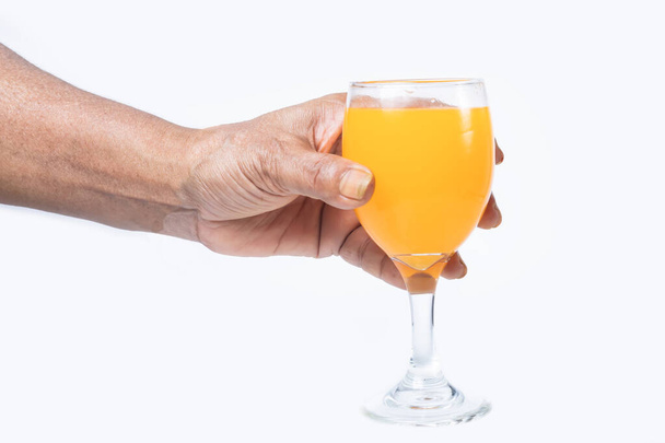 Hand hält Glas Orangen- oder Mangosaft isoliert auf weißem Hintergrund mit Clipping-Pfad - Foto, Bild