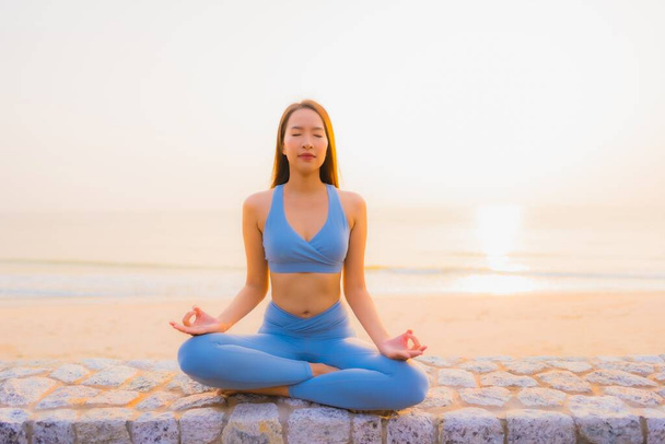 Ritratto giovane donna asiatica fare meditazione intorno mare spiaggia oceano al sorgere del sole per salute - Foto, immagini