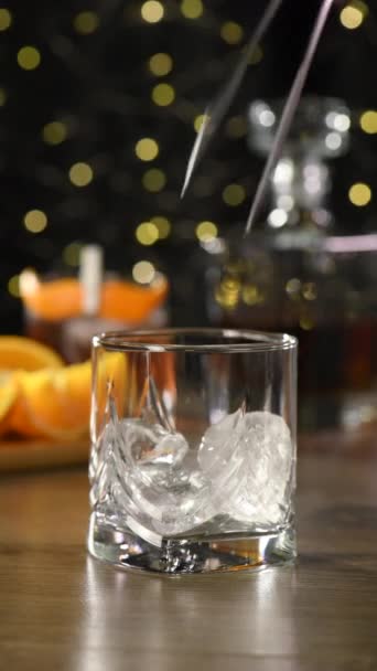 La moustache Sharpie est un cocktail facile à préparer avec du whisky de seigle à parts égales, du gin, du vermouth sucré et quelques gouttes d'amertume, et garni d'un zeste d'orange en forme de moustache. En temps réel. Vidéo verticale - Séquence, vidéo