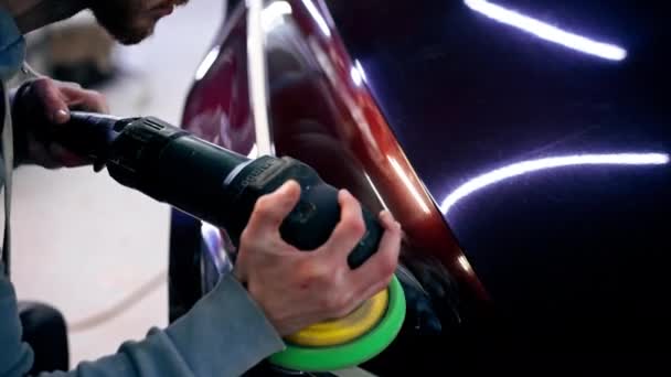 close-up van de handen van een automonteur bij een tankstation die de laatste polijstbeurt tot een glans doet - Video