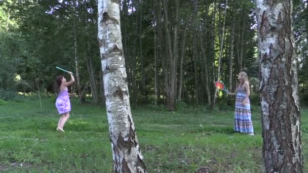 Беременная женщина с дочерью играют в бадминтон в парке
 - Кадры, видео