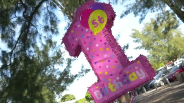 Pink 1st birthday piñata at the beach - Materiał filmowy, wideo