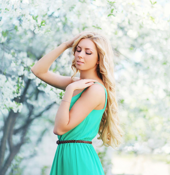 Spring portrait of lovely young woman enjoying in a flowering ga - Photo, Image