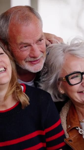 Vertikal. Fröhliche Senioren posieren für ein Foto und lachen zusammen im Innenraum. Ältere, gut gelaunte Freunde mit grauen Haaren umarmen sich. Lebensfreude reift mit Spaß im Pflegeheim - Filmmaterial, Video