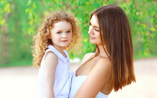 Portrait of happy mother and little daughter together in summer  - Fotó, kép