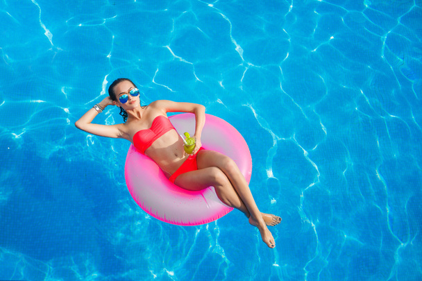 Beautiful girl in the pool on inflatable lifebuoy - 写真・画像