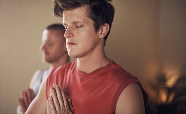 Man, prayer hands and peace for meditation with yoga for holistic wellness, mental health or healing in class. Person, namaste for mindfulness, stress relief and zen session with eyes closed and calm. - Photo, Image
