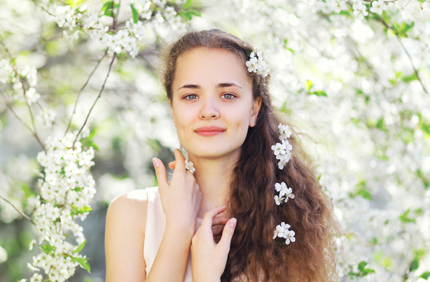 春の庭にかわいい女の子の花の肖像画 - 写真・画像