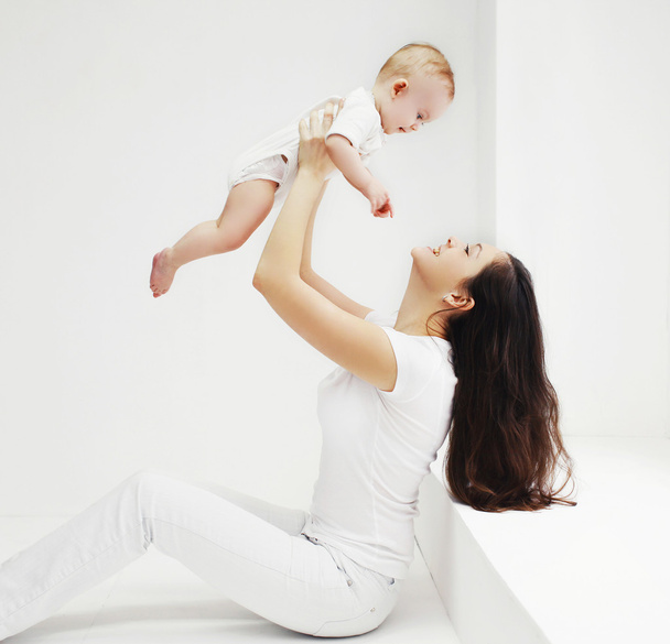 Happy family, mother and baby having fun together at home in whi - 写真・画像