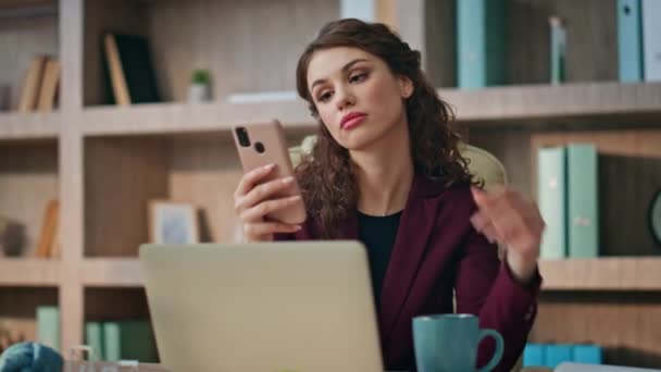 Morning businesswoman looking cellphone in office room. Bored girl drink coffee on work break closeup. Beautiful corporate brunette browsing mobile phone online sipping beverage at workplace buro. - Footage, Video