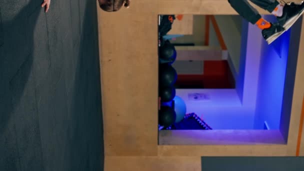 függőleges videó A tornateremben egy fiatal jóképű edző gyakorlatokat végez, miközben két kézen áll, és az erő egyensúlyát mutatja. - Felvétel, videó