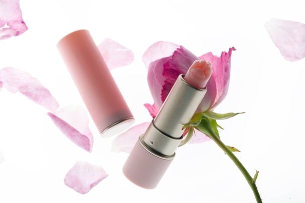 Lápiz labial rosa y pétalos de rosa
 - Foto, Imagen