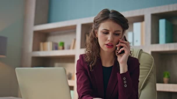 Απασχολημένος διευθυντής μιλάει κινητό τηλέφωνο αναζητούν οικονομικές εφημερίδες. Closeup γυναίκα μιλήσουμε smartphone σύμβουλος εταίρος στο χώρο εργασίας. Νέοι επαγγελματίες συζητούν τα δεδομένα της αγοράς εργασίας υπολογιστή on call in office - Πλάνα, βίντεο