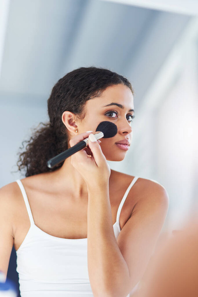 Makeup brush, mirror and black woman with beauty in bathroom for cosmetics, makeover or foundation. Lens Flare, hand and person with tools for contour powder, glowing skin or morning routine in home. - Valokuva, kuva