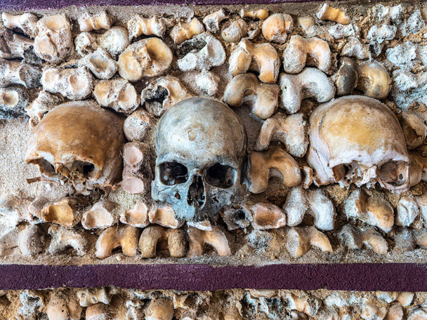 Portuguese chapel Capela Dos Ossos, Bones chapel next to Igreja do Carmo in Faro at Algarve in Portugal. Old wall graves and tombs with creepy bones and skulls of dead carmelite monks. - Photo, image