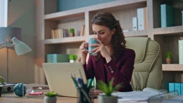 Calm employee drinking coffee in morning office. Smiling business manager rest sip beverage at corporate buro. Peaceful young businesswoman dreaming enjoying break at workplace. Company woman in suit - Footage, Video