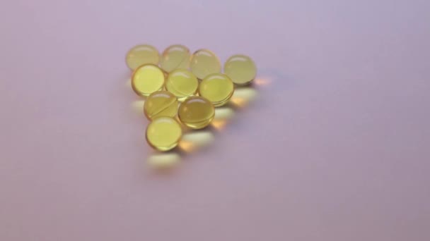 Transparent yellow capsules isolated on white - Footage, Video