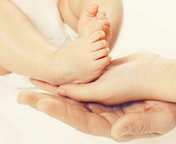 Closeup photo feet baby in hands mother and father - Foto, immagini